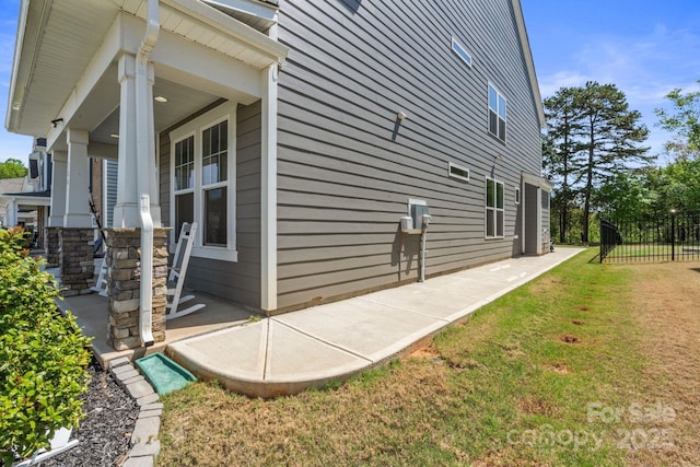 184 Tetcott St, Mooresville, NC 28115 - view of side of home with a lawn, fence, and a porch