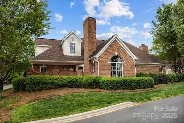 7502 Hurstbourne Green Dr, Charlotte, NC 28277 - view of front of house with brick siding, a chimney, a front yard, and roof with shingles