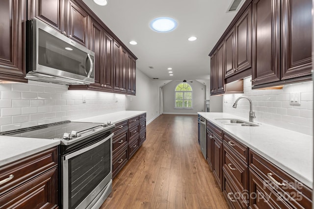 7502 Hurstbourne Green Dr, Charlotte, NC 28277 - kitchen with light countertops, visible vents, appliances with stainless steel finishes, light wood finished floors, and a sink