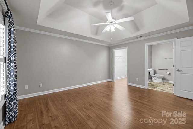 7502 Hurstbourne Green Dr, Charlotte, NC 28277 - unfurnished bedroom with a tray ceiling, wood finished floors, ensuite bath, and a spacious closet