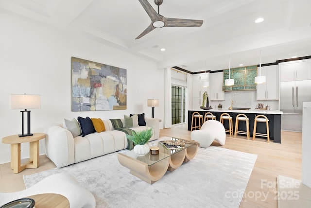 living area featuring beamed ceiling, a ceiling fan, recessed lighting, and light wood-style flooring