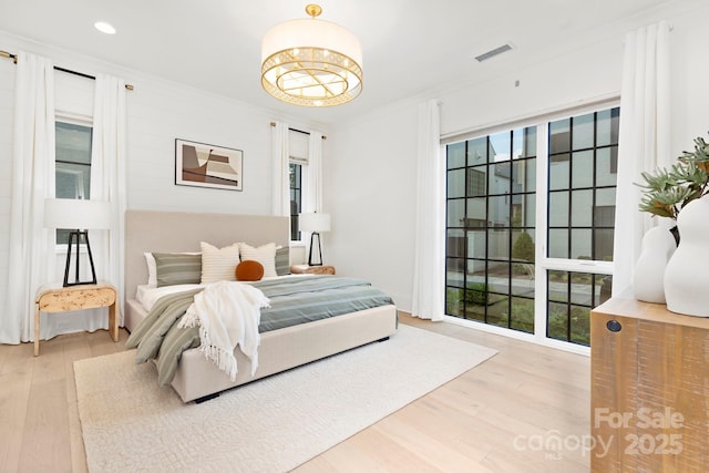 bedroom with visible vents, recessed lighting, crown molding, and wood finished floors