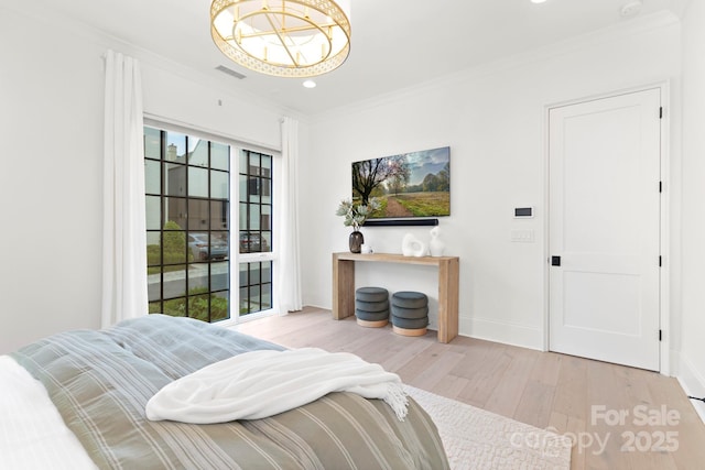 bedroom with visible vents, crown molding, wood finished floors, baseboards, and an inviting chandelier