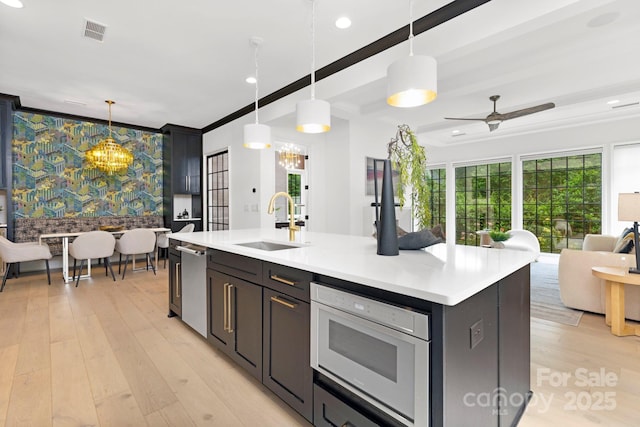 kitchen with a sink, a healthy amount of sunlight, open floor plan, and visible vents