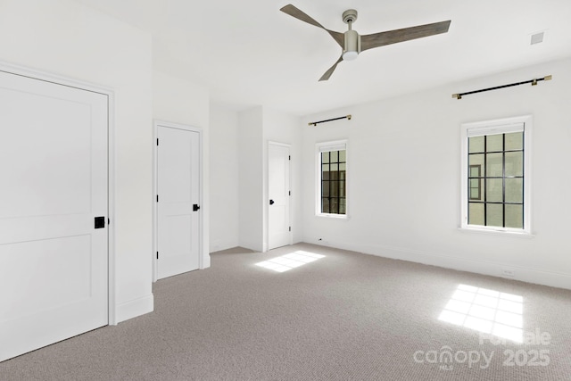 unfurnished bedroom with a ceiling fan, baseboards, visible vents, and carpet