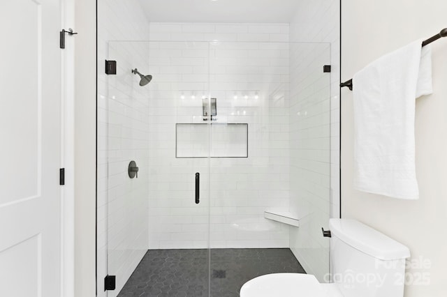 bathroom featuring a stall shower and toilet