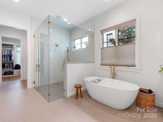 full bath with a freestanding tub, a shower stall, baseboards, a spacious closet, and recessed lighting