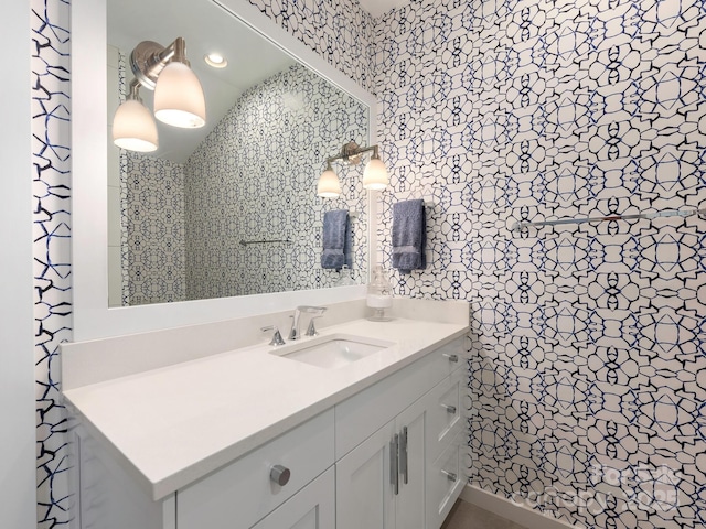 bathroom featuring wallpapered walls and vanity