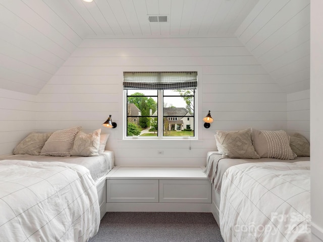 bedroom featuring vaulted ceiling, dark colored carpet, and visible vents
