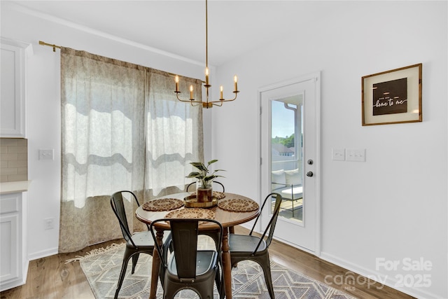 3153 Pinehills Way, Mount Holly, NC 28120 - dining room featuring an inviting chandelier, light wood finished floors, and a healthy amount of sunlight