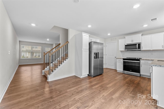 kitchen with baseboards, visible vents, white cabinetry, and appliances with stainless steel finishes