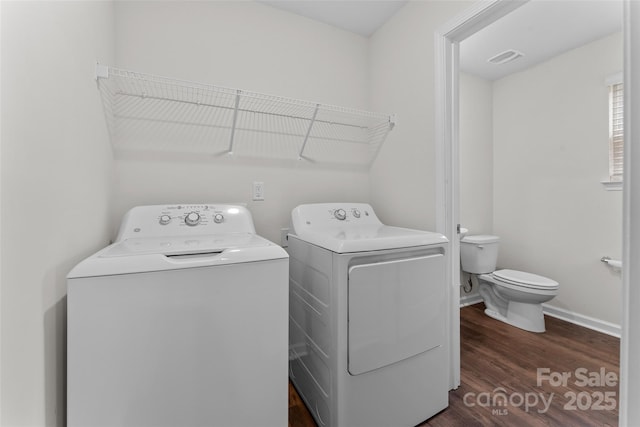 laundry area with washer and dryer, baseboards, dark wood-type flooring, and laundry area