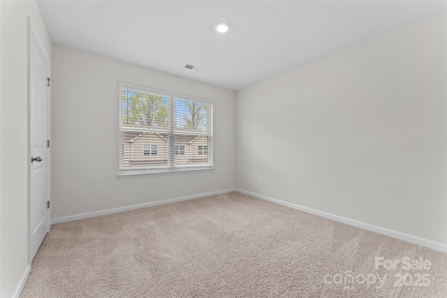 unfurnished room with baseboards, visible vents, and light colored carpet