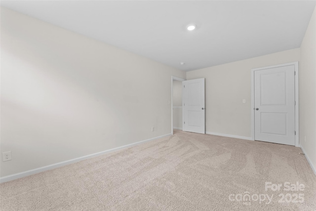 unfurnished bedroom featuring baseboards and light colored carpet