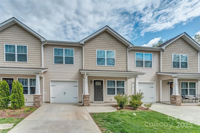 multi unit property with an attached garage, driveway, and a front yard