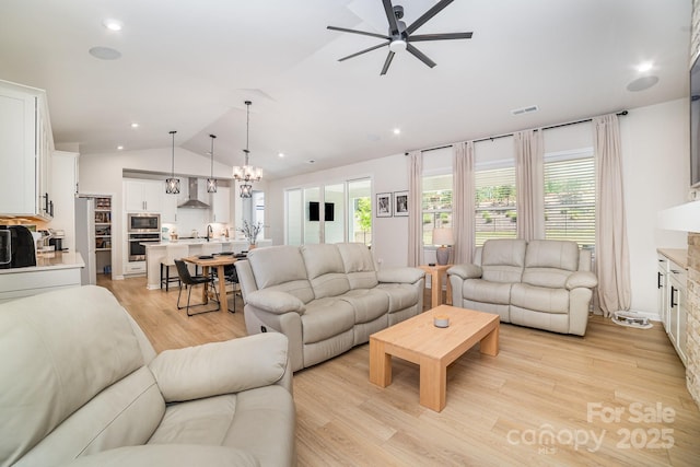 8011 Green Heron Ct, Belmont, NC 28012 - living room featuring a ceiling fan, vaulted ceiling, light wood-type flooring, recessed lighting, and a chandelier