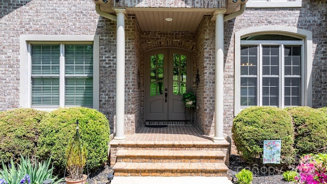 property entrance with brick siding and french doors