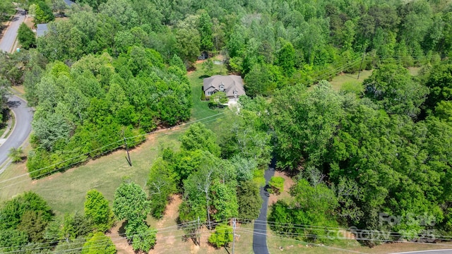 birds eye view of property featuring a forest view
