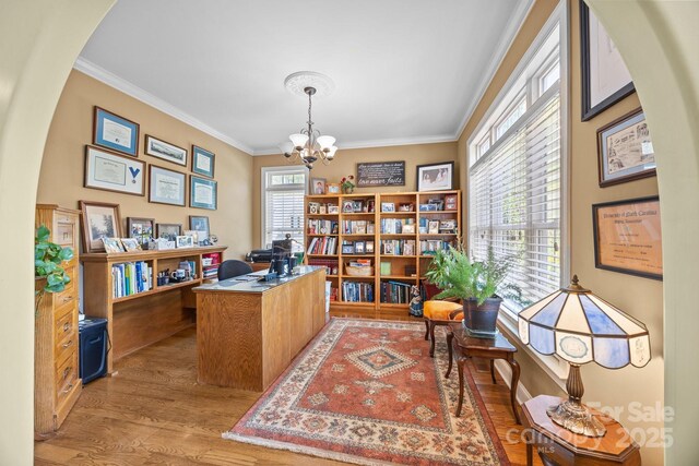 office area with crown molding, arched walkways, a notable chandelier, and wood finished floors