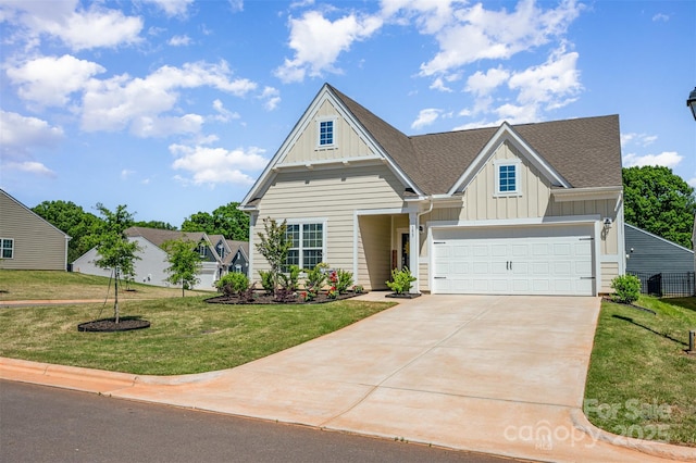 craftsman-style home featuring board and batten siding, an attached garage, driveway, and a front yard
