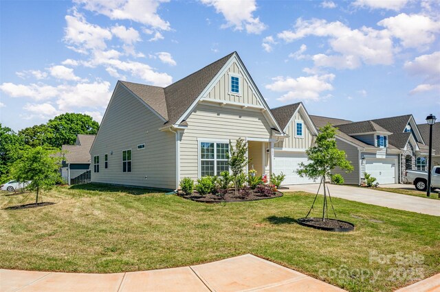 traditional-style home with board and batten siding, concrete driveway, a shingled roof, and a front lawn