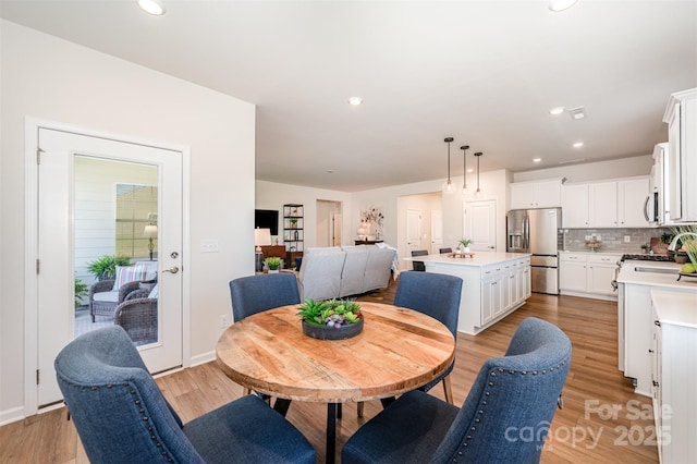 dining space with recessed lighting and light wood finished floors