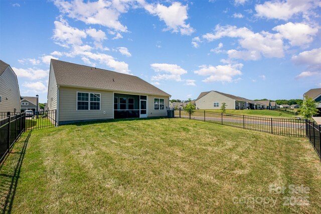 rear view of house featuring a lawn, a fenced backyard, and a residential view