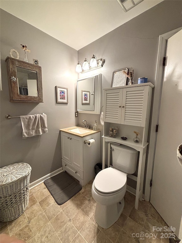 bathroom featuring visible vents, toilet, and vanity