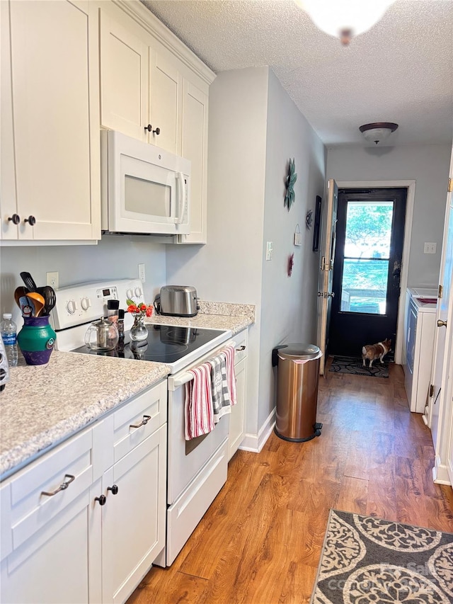 kitchen featuring light wood-type flooring, white appliances, a textured ceiling, and white cabinets