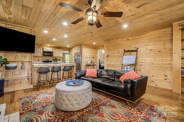 living area featuring wood walls, recessed lighting, light wood finished floors, and ceiling fan