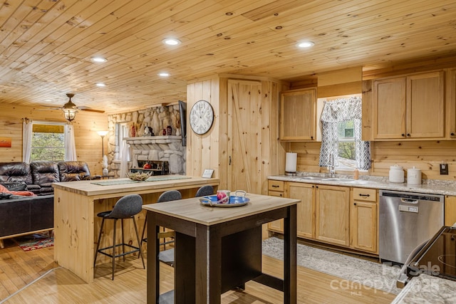 kitchen with a sink, open floor plan, dishwasher, and light brown cabinets