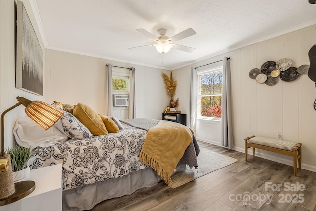 bedroom featuring cooling unit, multiple windows, crown molding, and wood finished floors