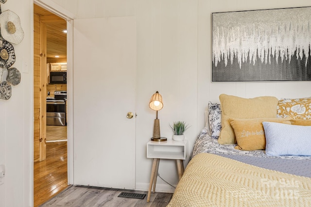 bedroom featuring visible vents and wood finished floors
