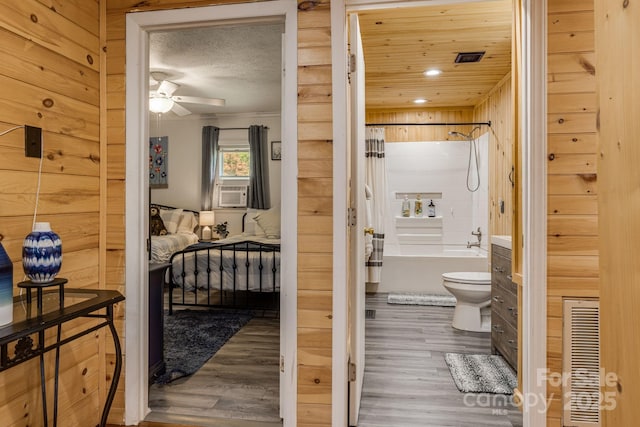bathroom with shower / bath combination, ceiling fan, toilet, and wood finished floors