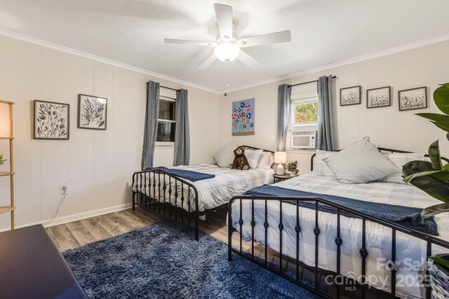 bedroom with ornamental molding, a ceiling fan, wood finished floors, and a textured ceiling