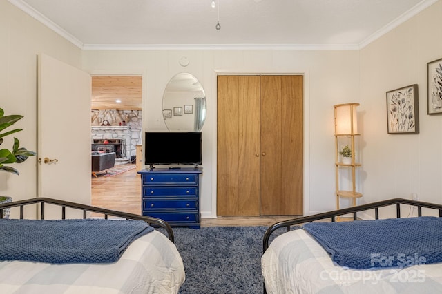 bedroom with ornamental molding and wood finished floors