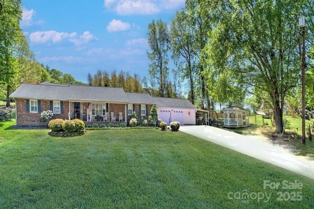 single story home with concrete driveway, a front lawn, an attached garage, a porch, and brick siding