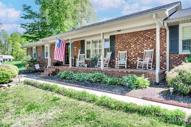 view of front of home with covered porch and brick siding
