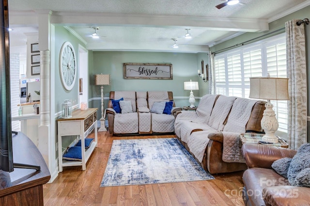 living area featuring baseboards, a ceiling fan, wood finished floors, and crown molding
