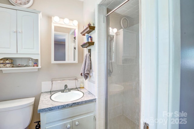 full bath with toilet, vanity, and a stall shower