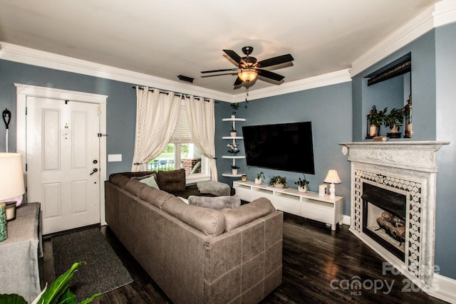 living area with crown molding, wood finished floors, baseboards, and a ceiling fan
