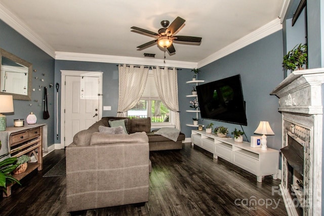 living area with crown molding, ceiling fan, wood finished floors, and a fireplace
