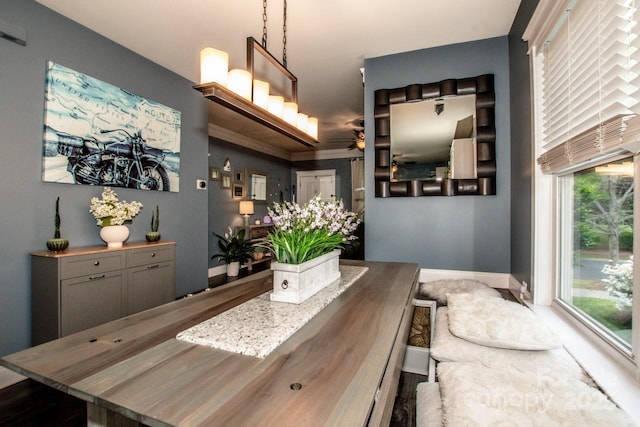 dining space featuring a ceiling fan and baseboards