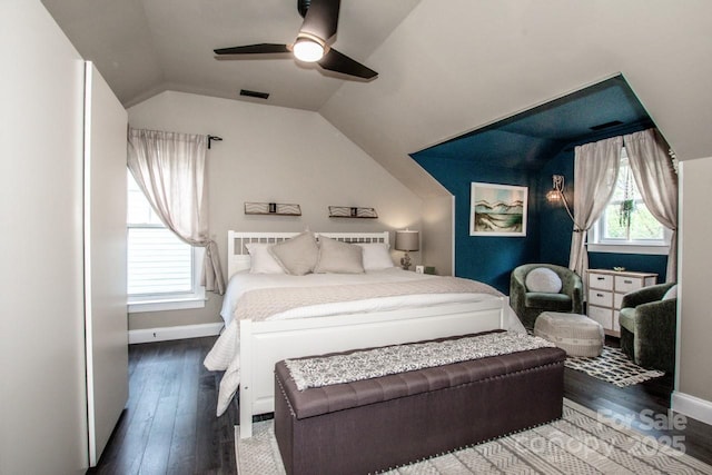 bedroom with wood finished floors, visible vents, lofted ceiling, and baseboards