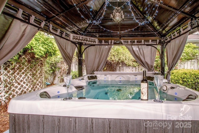 exterior space with fence and a hot tub