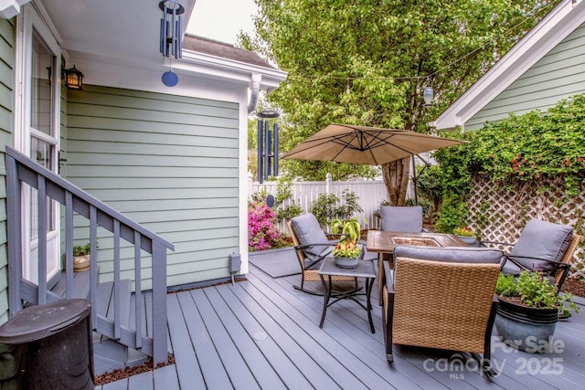 wooden terrace featuring fence and outdoor dining area