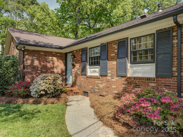 view of front of house featuring brick siding and a shingled roof