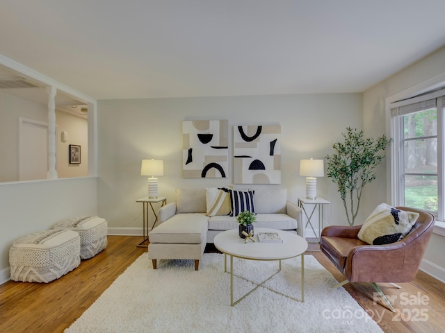 living area featuring wood finished floors, visible vents, and baseboards