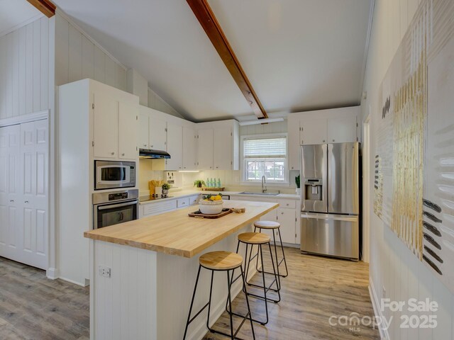 kitchen with white cabinets, light wood-style flooring, stainless steel appliances, and a sink