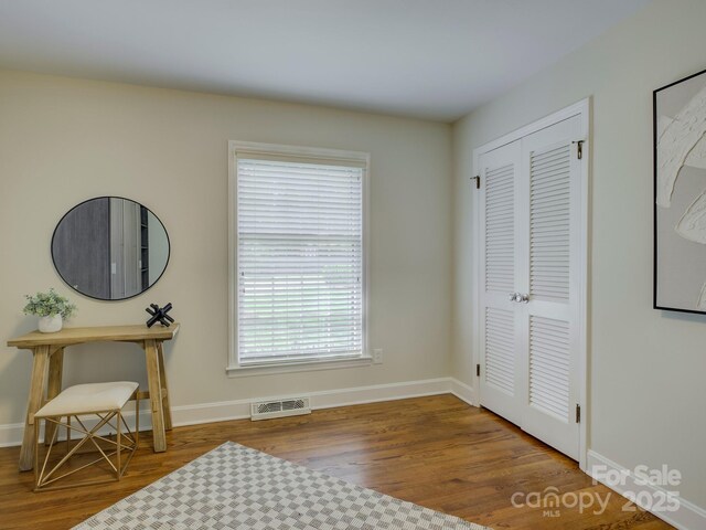 interior space featuring wood finished floors, visible vents, and baseboards